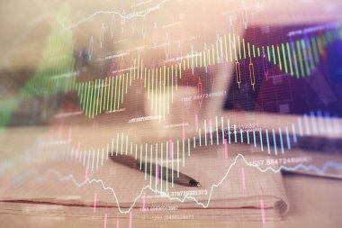 Finansal grafik çizimleri ve açık defter arkaplanı olan bir masa. Önx pazarı kavramı