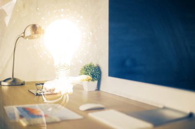 Bilgisayar ofisinde ampul simgesi hologramıyla birlikte. Çifte maruziyet. Fikir kavramı.