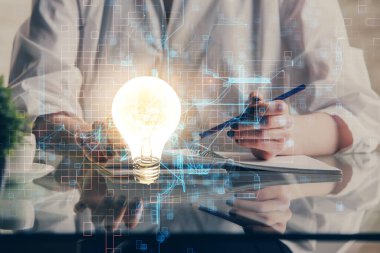 Arka planda not alan bir kadının eline ampul çizmek. Fikir kavramı. Çift pozlama