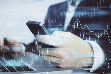 Dijital telefon ve forx grafik çizimi kullanarak adamın elini tutarken birden fazla pozlama. Finansal piyasa kavramı.