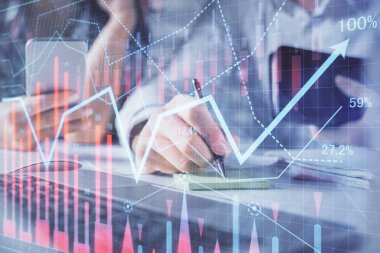 Kadın ve erkeğin birlikte çalışması ve finansal grafik hologramı. İş konsepti. Bilgisayar arkaplanı.