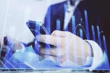Dijital telefon ve forx grafik çizimi kullanarak adamın elini tutarken birden fazla pozlama. Finansal piyasa kavramı.