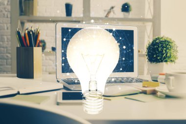 Bilgisayar ofisinde ampul simgesi hologramıyla birlikte. Çifte maruziyet. Fikir kavramı.