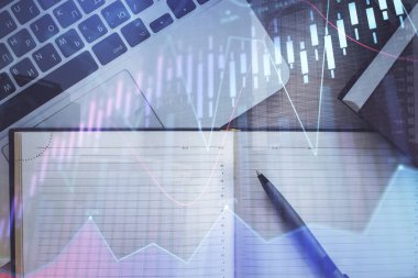 Borsa grafiği ve masa arkasındaki en üst görünüm bilgisayarı. Çoklu maruz kalma. Finansal eğitim kavramı.