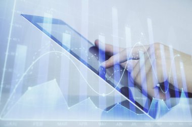 Dijital telefon ve forx grafik çizimi kullanarak adamın elini tutarken birden fazla pozlama. Finansal piyasa kavramı.