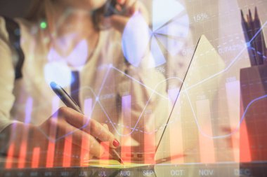 Bilgisayarda ve finansal grafik hologramında kadın eli yazarken çift pozlama. Borsa analizi kavramı.