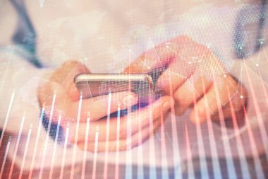 Dijital telefon ve forx grafik çizimi kullanarak adamın elini tutarken birden fazla pozlama. Finansal piyasa kavramı.