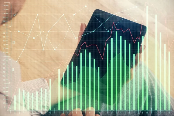 Double exposure of man\'s hands holding and using a digital device and forex graph drawing. Financial market concept.