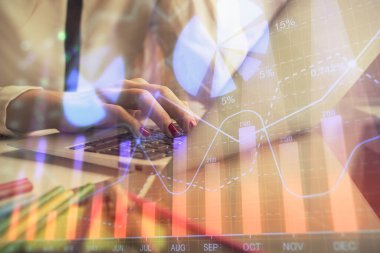 Bilgisayarda ve finansal grafik hologramında kadın eli yazarken çift pozlama. Borsa analizi kavramı.
