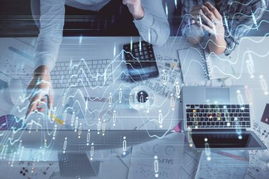 Kadın ve erkeğin birlikte çalışması ve finansal grafik hologramı çizimi. Pazar analizi konsepti. Bilgisayar arkaplanı. Üst Görünüm.