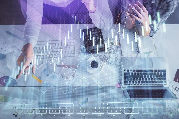 Kadın ve erkeğin birlikte çalışması ve finansal grafik hologramı çizimi. Pazar analizi konsepti. Bilgisayar arkaplanı. Üst Görünüm.