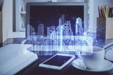 Ofisteki masaüstü bilgisayar geçmişi ve büyük kasaba binaları hologram çizimi. Çifte maruziyet. Akıllı şehir konsepti.