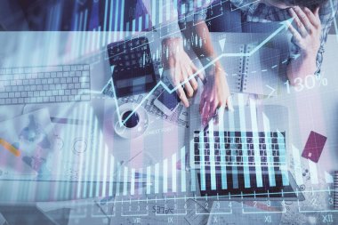 Kadın ve erkeğin birlikte çalışması ve finansal grafik hologramı çizimi. Pazar analizi konsepti. Bilgisayar arkaplanı. Üst Görünüm.