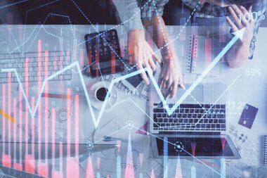 Kadın ve erkeğin birlikte çalışması ve finansal grafik hologramı çizimi. Pazar analizi konsepti. Bilgisayar arkaplanı. Üst Görünüm.