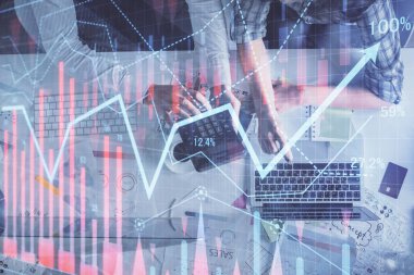 Kadın ve erkeğin birlikte çalıştığı çoklu pozlama ve grafik hologramı çizimi. Finansal analiz konsepti. Bilgisayar arkaplanı. Üst Görünüm.