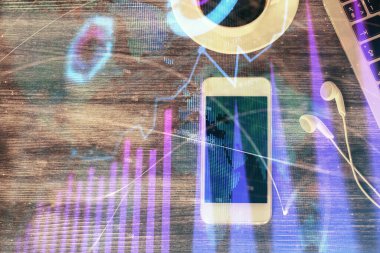 Masaüstünde telefonlu ön x grafik hologramına çift pozlama. Üst Manzara. Mobil ticaret platformu kavramı.