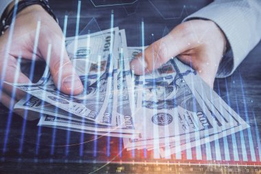 Finansal grafiğe çoklu pozlama hologram, Amerikan dolarları ve insan eli. Analiz kavramı.