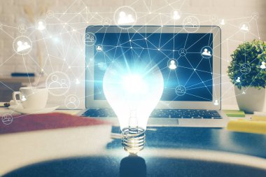 Bilgisayar ofisinde ampul simgesi hologramıyla birlikte. Çifte maruziyet. Fikir kavramı.