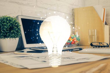 Bilgisayar ofisinde ampul simgesi hologramıyla birlikte. Çifte maruziyet. Fikir kavramı.
