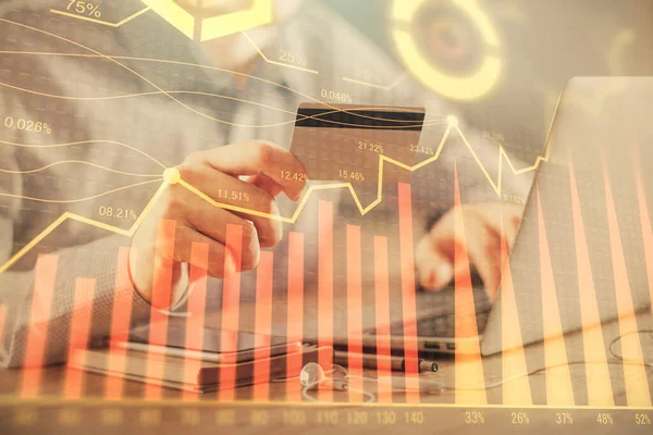Ellerinde kredi kartı ve forex çizimi olan bir adamın çift pozu. İnternet E-ticaret kavramında hisse senedi ve dijital fintech.
