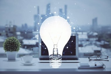 Bilgisayar ofisinde ampul simgesi hologramıyla birlikte. Çifte maruziyet. Fikir kavramı.