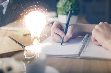 Kadın elinin üstüne ampul çizip arka planda not almak. Fikir kavramı. Çift pozlama