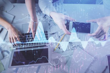 Kadın ve erkeğin birlikte çalıştığı çoklu pozlama ve grafik hologramı çizimi. Finansal analiz konsepti. Bilgisayar arkaplanı. Üst Görünüm.