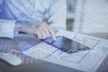 Erkeklerin el ele tutuşup dijital bir cihaz ve ön grafik çizimi kullanırken çift pozlama. Finansal piyasa kavramı.