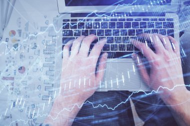 Dizüstü bilgisayarda klavye ve forx grafik hologram çizimlerini yazarken çift pozlama. Üst Manzara. Finans piyasası kavramı.