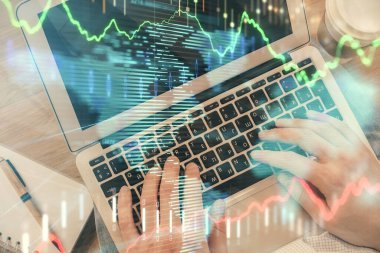 İnsan elinin bilgisayar klavyesinde ve forx grafik hologramının üzerinde yazarken çifte pozlama. Üst Manzara. Finans piyasası kavramı.