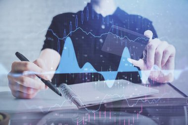Ellerinde kredi kartı ve forex çizimi olan bir adamın çift pozu. İnternet E-ticaret kavramında hisse senedi ve dijital fintech.
