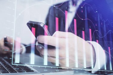 Dijital telefon ve forx grafik çizimi kullanarak adamın elini tutarken birden fazla pozlama. Finansal piyasa kavramı.