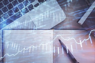 Borsa grafiği ve masa arkasındaki en üst görünüm bilgisayarı. Çoklu maruz kalma. Finansal eğitim kavramı.