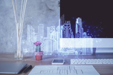 Ofisteki masaüstü bilgisayar geçmişi ve büyük kasaba binaları hologram çizimi. Çifte maruziyet. Akıllı şehir konsepti.