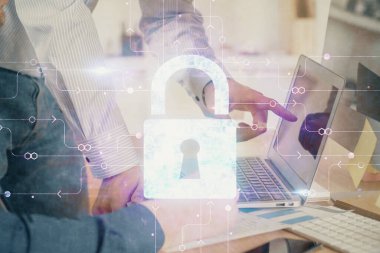 Arka planda bilgisayarda çalışan bir adamla birden fazla kilit simgesine maruz kalma. Ağ koruma kavramı.