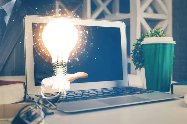 Computer sul desktop in ufficio con ologramma icona lampadina. Doppia esposizione. Concetto di idea. — Foto Stock