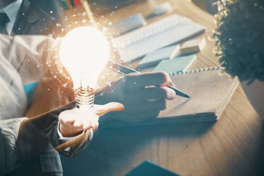 Kadın elinin üstüne ampul çizip arka planda not almak. Fikir kavramı. Çift pozlama