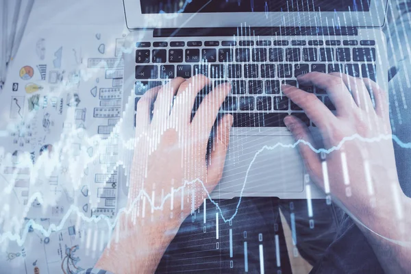 Double exposition des mains mans tapant sur le clavier de l'ordinateur portable et le dessin de l'hologramme du graphique forex. Vue de dessus. Concept de marchés financiers. — Photo