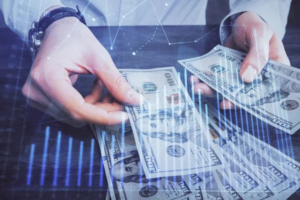 Wielokrotna ekspozycja wykresu finansowego rysującego hologram i dolary amerykańskie rachunki i ręce człowieka. Koncepcja analizy. — Zdjęcie stockowe