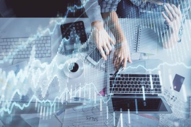 Kadın ve erkeğin birlikte çalışması ve finansal grafik hologramı çizimi. Pazar analizi konsepti. Bilgisayar arkaplanı. Üst Görünüm.