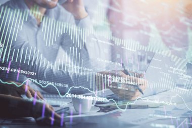 Kadın ve erkeğin birlikte çalışması ve finansal grafik hologramı. İş konsepti. Bilgisayar arkaplanı.