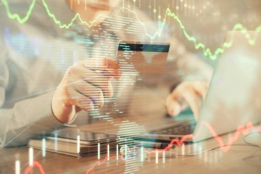 Ellerinde kredi kartı ve forex çizimi olan bir adamın çift pozu. İnternet E-ticaret kavramında hisse senedi ve dijital fintech.