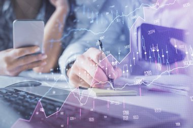 Kadın ve erkeğin birlikte çalışması ve finansal grafik hologramı. İş konsepti. Bilgisayar arkaplanı.