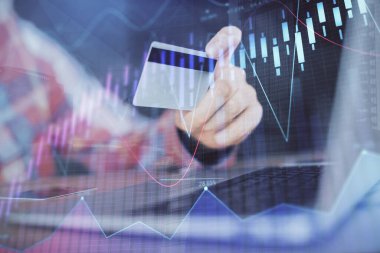 Ellerinde kredi kartı ve forex çizimi olan bir adamın çift pozu. İnternet E-ticaret kavramında hisse senedi ve dijital fintech.