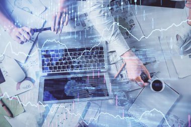Kadın ve erkeğin birlikte çalışması ve finansal grafik hologramı. İş konsepti. Bilgisayar arkaplanı.