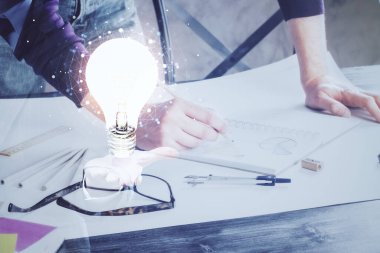 Ampul lambası fikir simgesinin gelecek arayüzü ve yazma adamı el altyapısı üzerindeki görüntüsü. Çift pozlama.