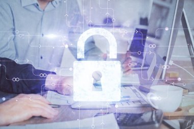 Arka planda bilgisayarda çalışan bir adamla birden fazla kilit simgesine maruz kalma. Ağ koruma kavramı.