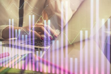 Bilgisayarda ve finansal grafik hologramında kadın eli yazarken çift pozlama. Borsa analizi kavramı.