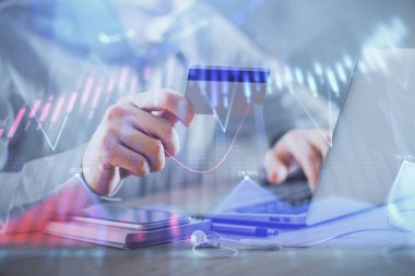 Ellerinde kredi kartı ve forex çizimi olan bir adamın çift pozu. İnternet E-ticaret kavramında hisse senedi ve dijital fintech.