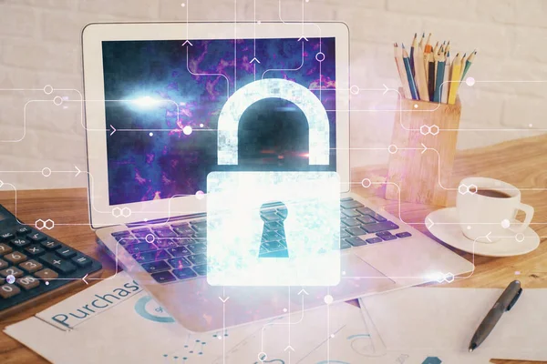 Double exposure of desktop with computer and lock icon hologram. Concept of data safety.